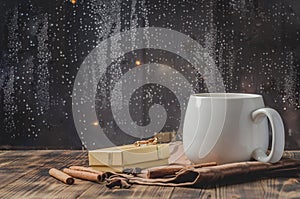 Eggnog. Traditional christmas cocktail in a mug with anise and cinnamon sticks, christmas gift box on a wooden table. Background