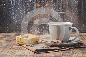 Eggnog. Traditional christmas cocktail in a mug with anise and cinnamon sticks, christmas gift box on a wooden table. Background