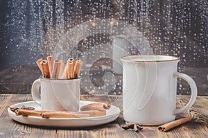 Eggnog. Traditional christmas cocktail in a mug with anise and cinnamon sticks in a small cup on a wooden table. Background of