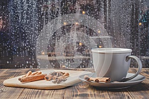 Eggnog. Traditional christmas cocktail in a mug with cinnamon sticks and anise on napkin and wooden table. Background of night wet