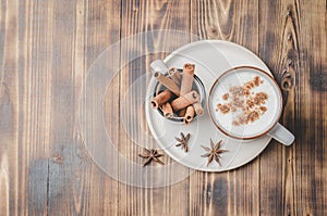 Eggnog. Traditional christmas cocktail in a mug and cinnamon sticks on a on a white bowl on a wooden background. Copyspace and top