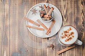 Eggnog. Traditional christmas cocktail in a mug and cinnamon sticks on a on a white bowl on a wooden background. Copyspace and top