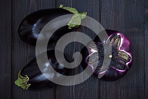 Eggplant (aubergine) on dark wooden table. Top view. Fresh raw farm vegetables - harvest from the garden in rustic kitch