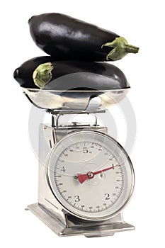 Eggplant on a kitchen scale close up on white background