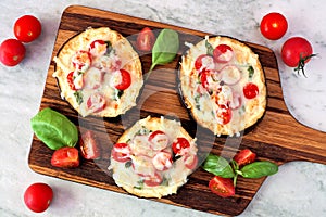 Eggplant mini pizzas on a serving board against marble