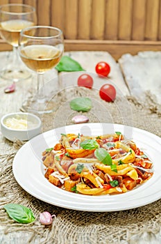 Eggplant tomato basil pasta in a plate on a wood backround