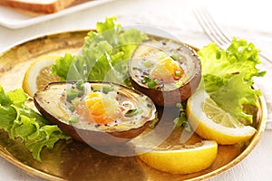 Eggs baked in avocado on plate, closeup