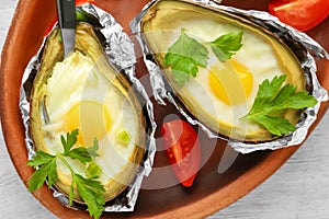 Eggs baked in avocado on plate, closeup