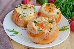 Eggs baked in a bun with ham, cheese and herbs.