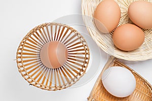 Eggs in bamboo weave basket on white