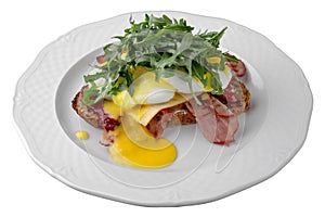 Eggs Benedict. Breakfast dish, which is a sandwich made from two halves of a bun with poached eggs, ham or bacon