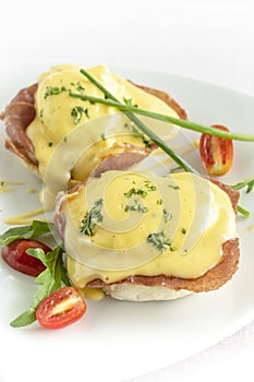 Eggs benedict breakfast with ham and hollandaise sauce