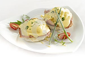 Eggs benedict breakfast with ham and hollandaise sauce