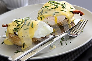 Eggs Benedict dish consisting of poached eggs and sliced ham on toasted muffins