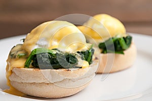 Eggs benedict or eggs florentine on a white plate in the cafe photo