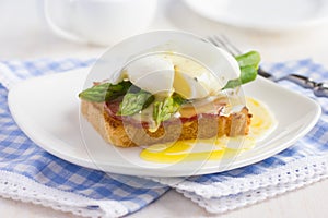 Eggs Benedict with hollandaise sauce on toast with bacon and as