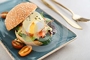 Eggs Benedict with salad leafs, salmon and fresh cherry tomato