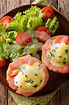 Eggs Benedict with salmon and hollandaise sauce close-up. Vertical top view