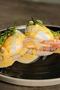Eggs Benedict with salmon on a wooden table