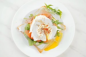 Eggs Benedict with smoked salmon, herbs, and hollandaise sauce
