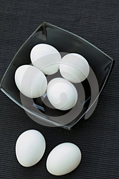 Eggs in a black bowl isoated on black background.