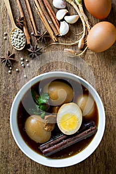 Eggs boiled in the gravy with spices on wooden background. Thai cuisine (Kai pa lo).