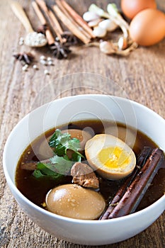 Eggs boiled in the gravy with spices on wooden background.Thai cuisine (Kai pa lo)