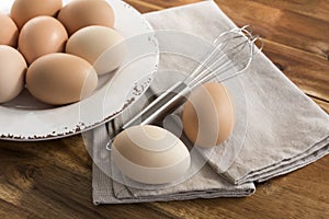 Eggs in bowl, whisk, napkin.