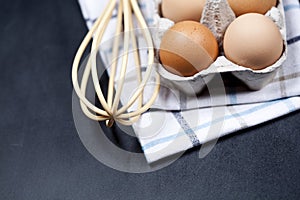 Eggs in cardboard box, towel and whisker closeup on backboard background