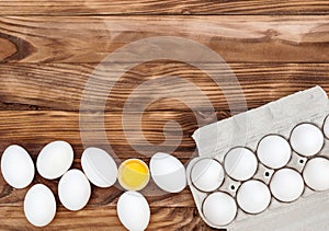 Eggs and carton container with eggs on wooden background. Copy space for text. Top view