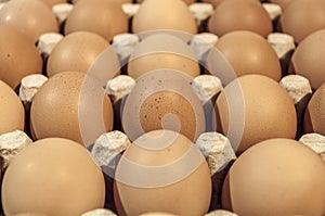 Eggs in carton package on a wooden table for baking, close up