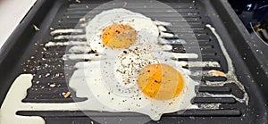 Eggs cooked with rosemary spice on a square grill pan