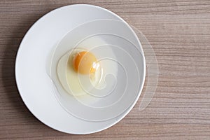 Eggs cooking for breakfast, a protein form yolk and albumen on a white background, or on a plain wooden table.