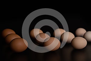 Eggs of different shades lie in rows on a black background