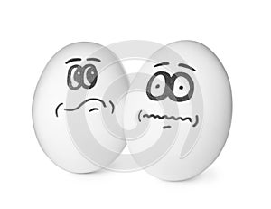 Eggs with drawn thoughtful and frightened faces on white background