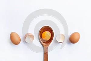 Eggs, egg yolk on wooden spoon isolated