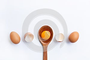Eggs, egg yolk on wooden spoon isolated photo