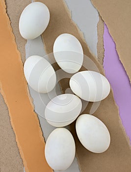 Eggs flat lay on pastel torn papers abstract texture background. Food egg styling, still life photography.
