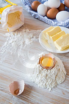 Eggs, flour, butter, pasta or baking ingredients on a wooden table . Selective focus