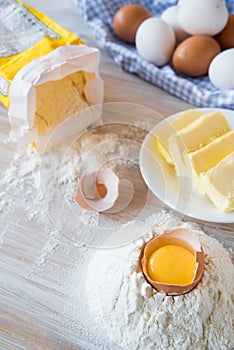 Eggs, flour, butter, pasta or baking ingredients on a wooden table . Selective focus