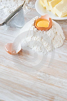 Eggs, flour, butter, pasta or baking ingredients on a wooden table . Selective focus