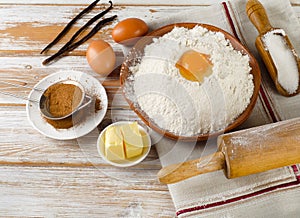Eggs, flour, sugar, butter on white wooden table