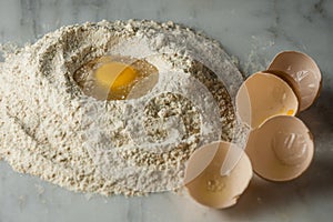 Eggs in flour on white marble