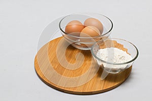 Eggs and flour on white table background. basic baking background.