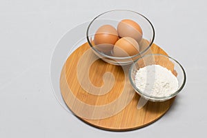Eggs and flour on white table background. basic baking background.