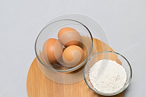 Eggs and flour on white table background. basic baking background.