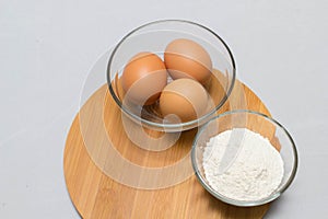 Eggs and flour on white table background. basic baking background.