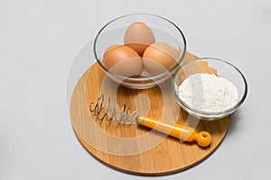 Eggs and flour on white table background. basic baking background.