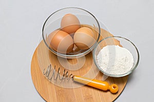 Eggs and flour on white table background. basic baking background.