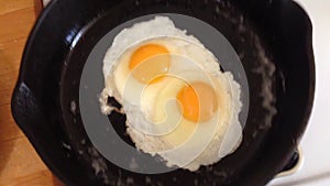 Eggs Frying in Cast Iron Pan.